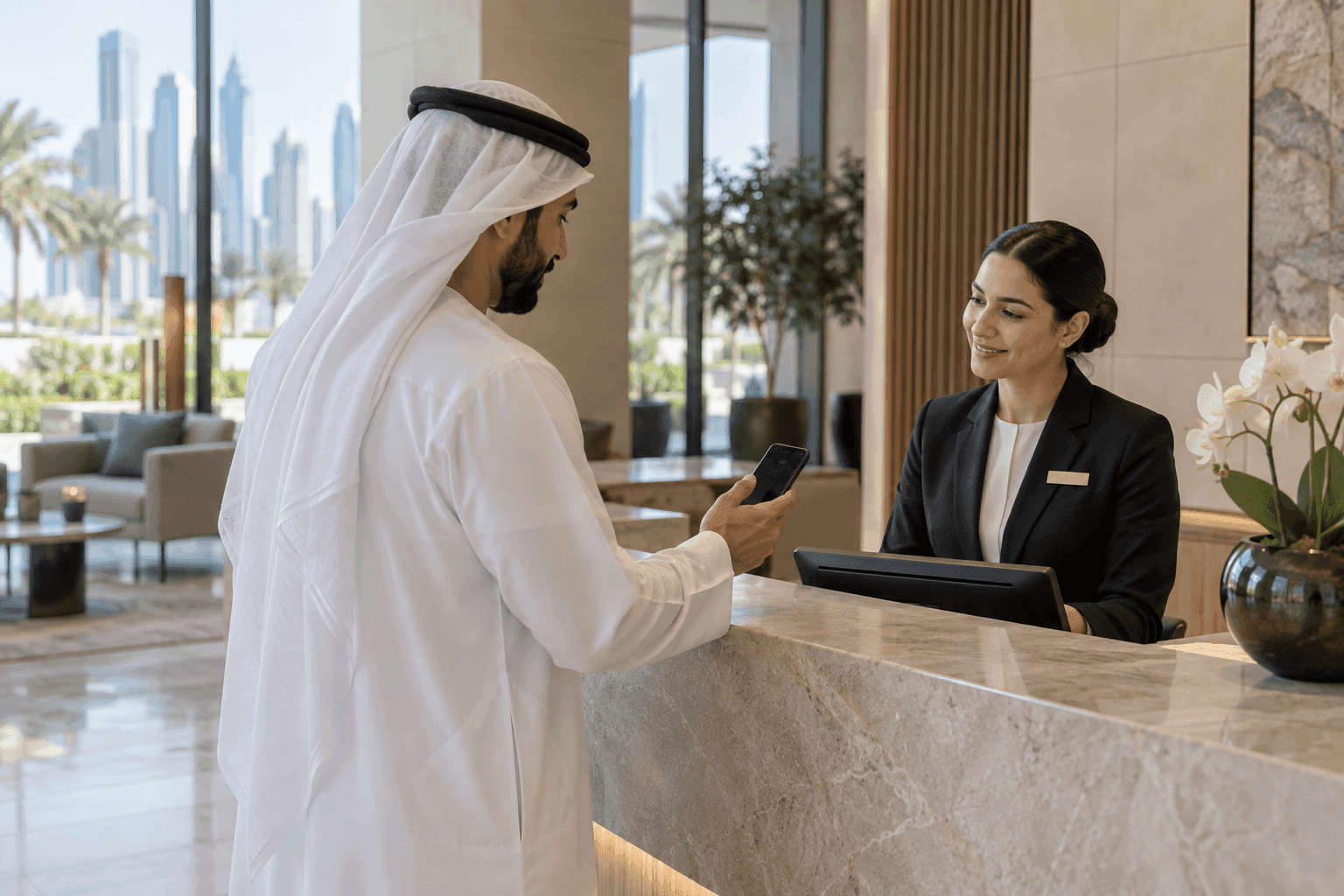 Resident using phone at a residential service desk, screen facing away, UAE contemporary setting
